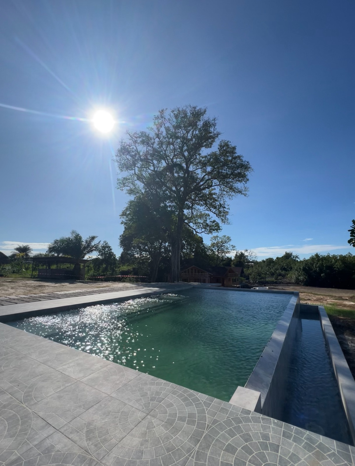 Piscine de Ndossi Village face à la rivière Tsini, avec chaises longues